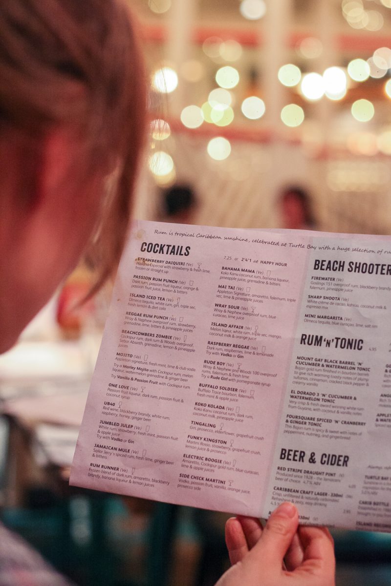 My friend having a read of the cocktail menu at Turtle Bay