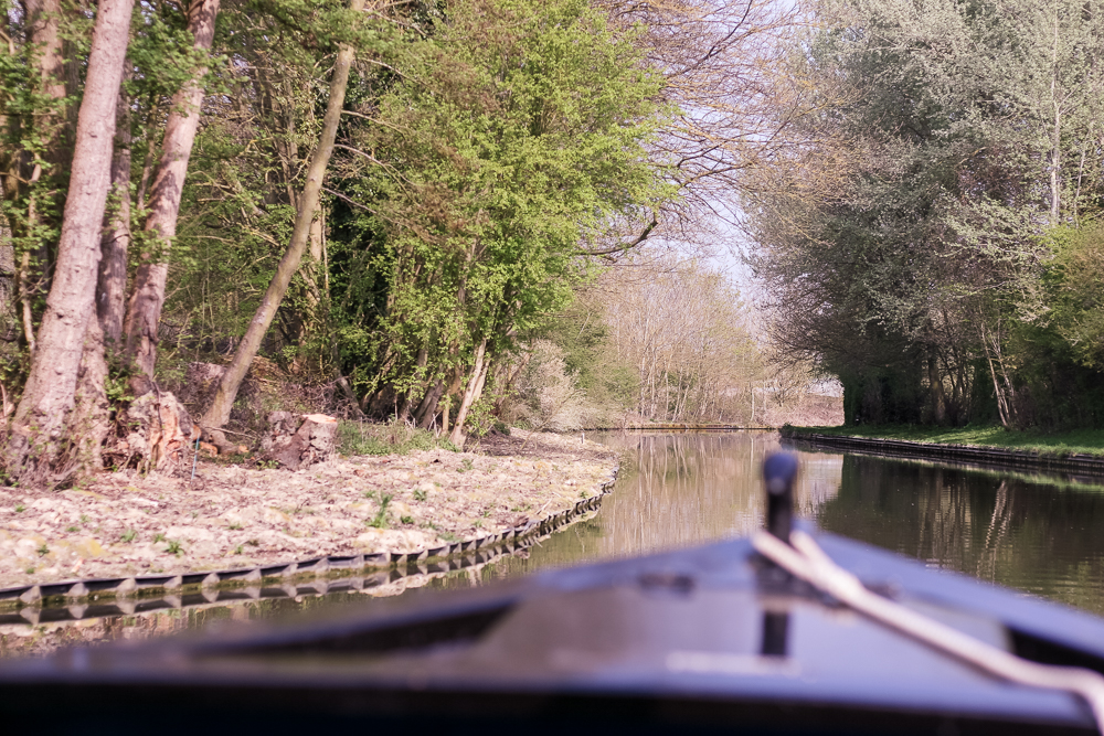 The front of the canal boat out of focus, looking at the route ahead.
