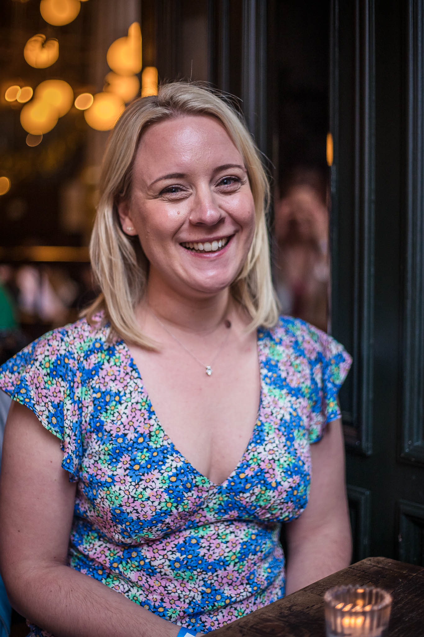 Smiling Holly sat at a table with a lit tealight candle at The Lost and Found in Birmingham